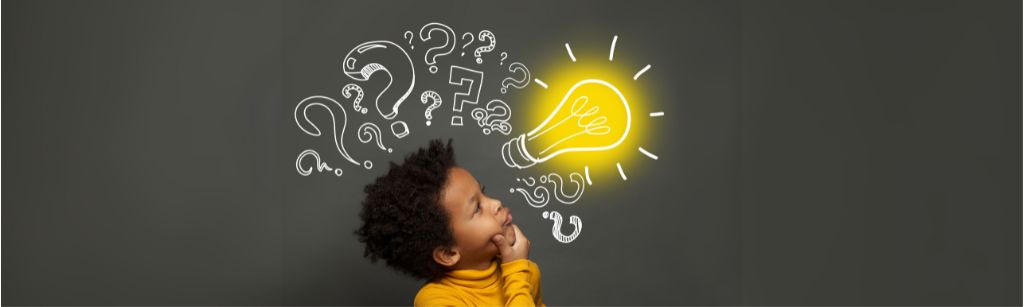 child with doodled questions behind them on a blackboard