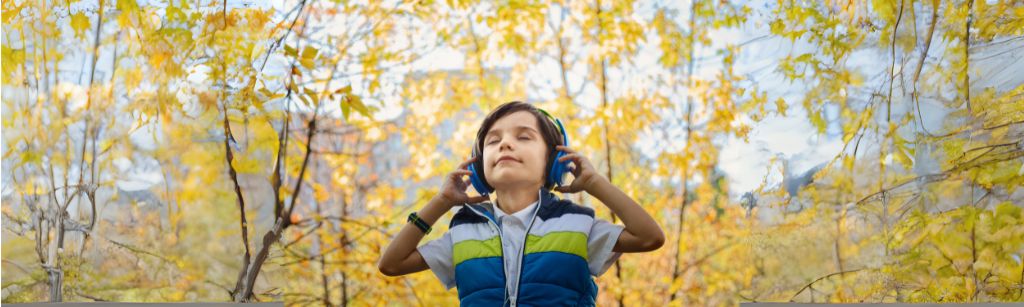 kid in forest with eyes closed and headphones on