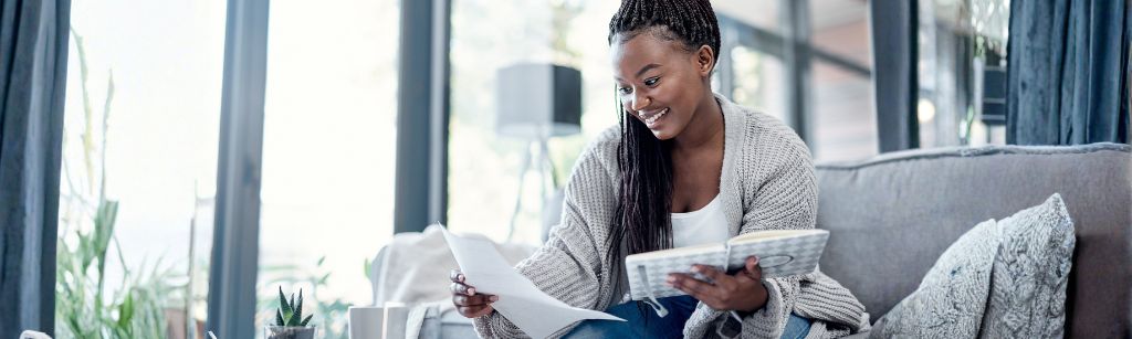 woman on couch with book and organizer writing